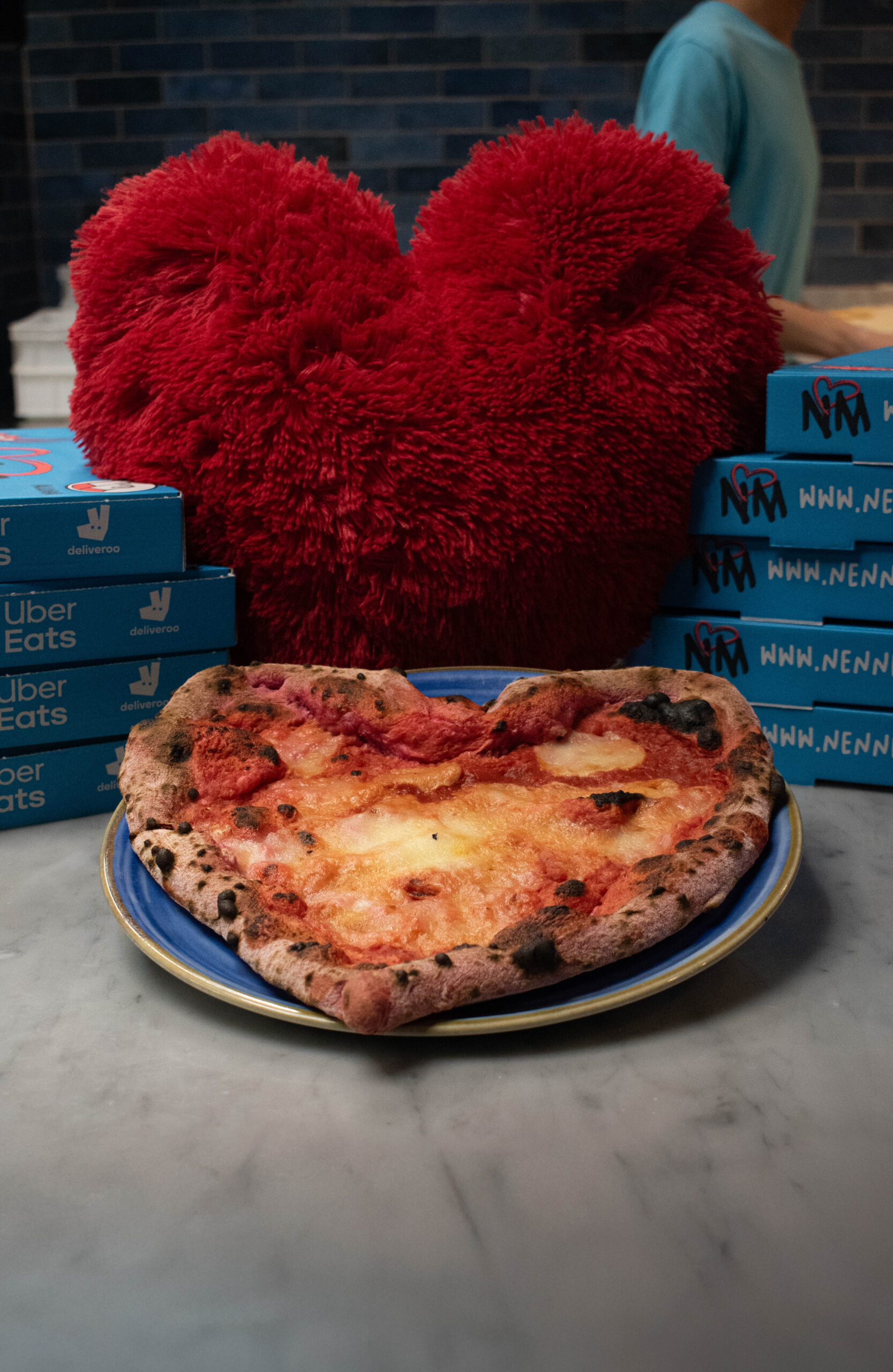 Sliced Neapolitan pizza on a wooden board with basil and melted mozzarella