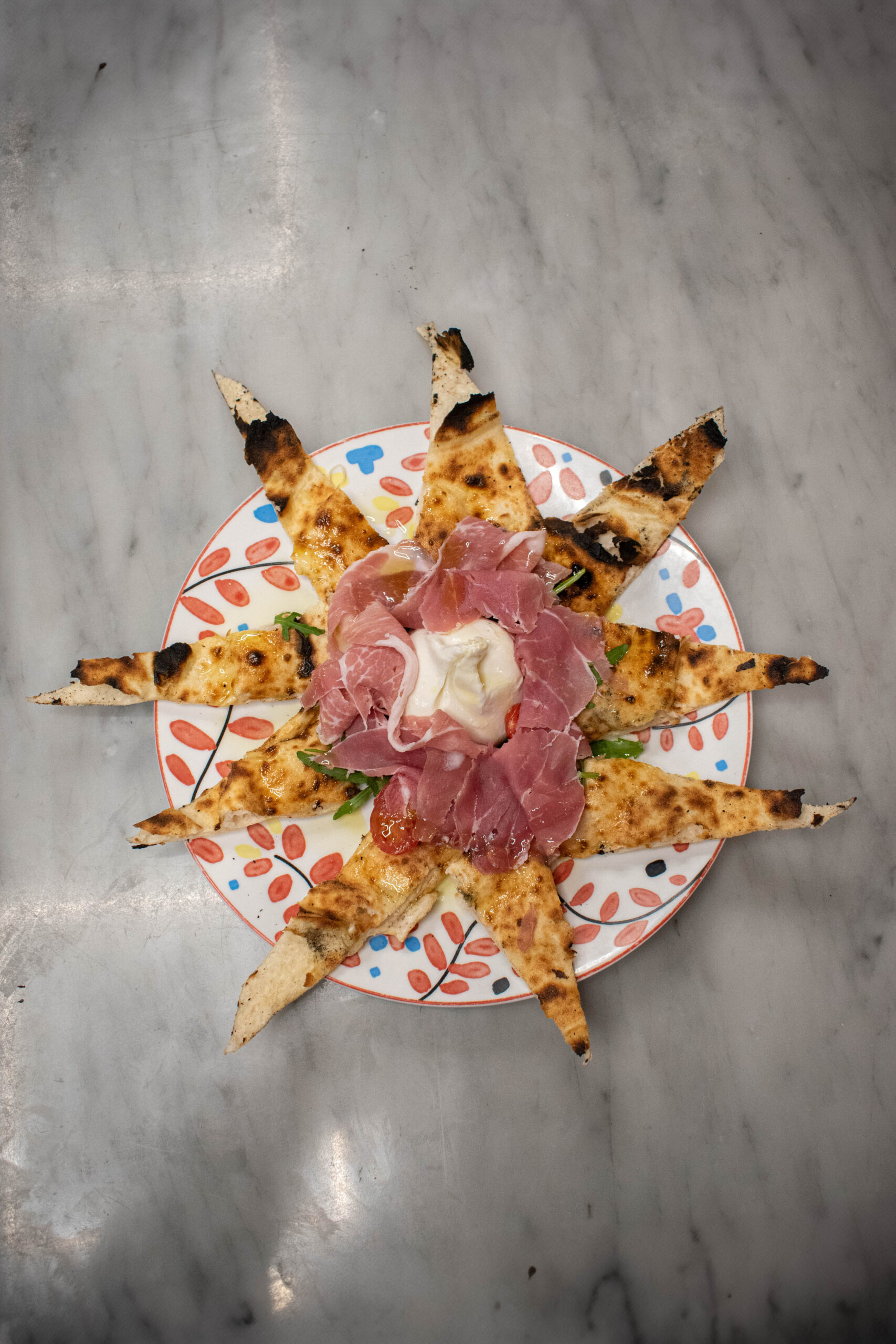 Salle chaleureuse type trattoria, clients attablés et pizzas servies au comptoir