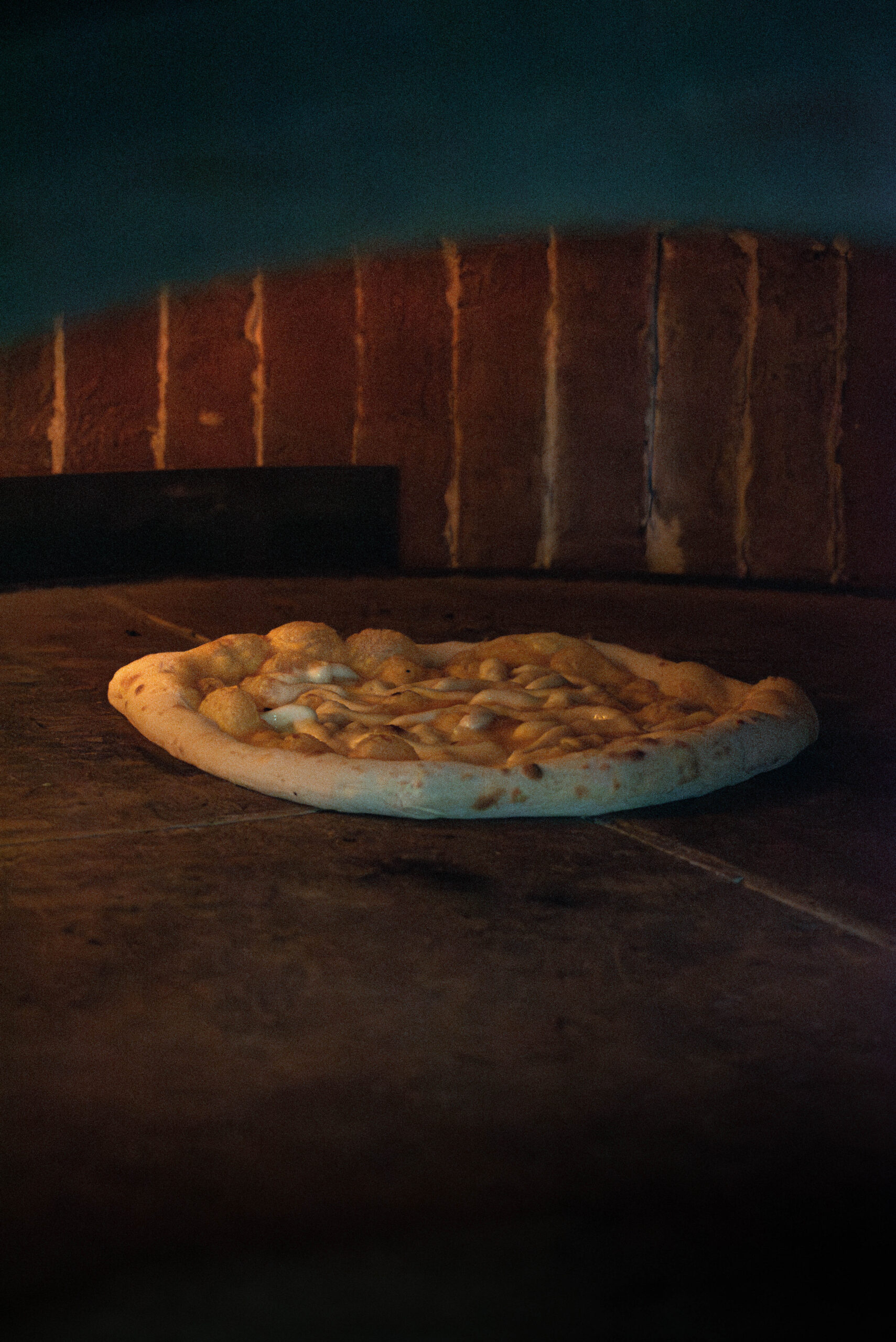 Pizza napolitaine au basilic, croûte gonflée, servie sur table en bois