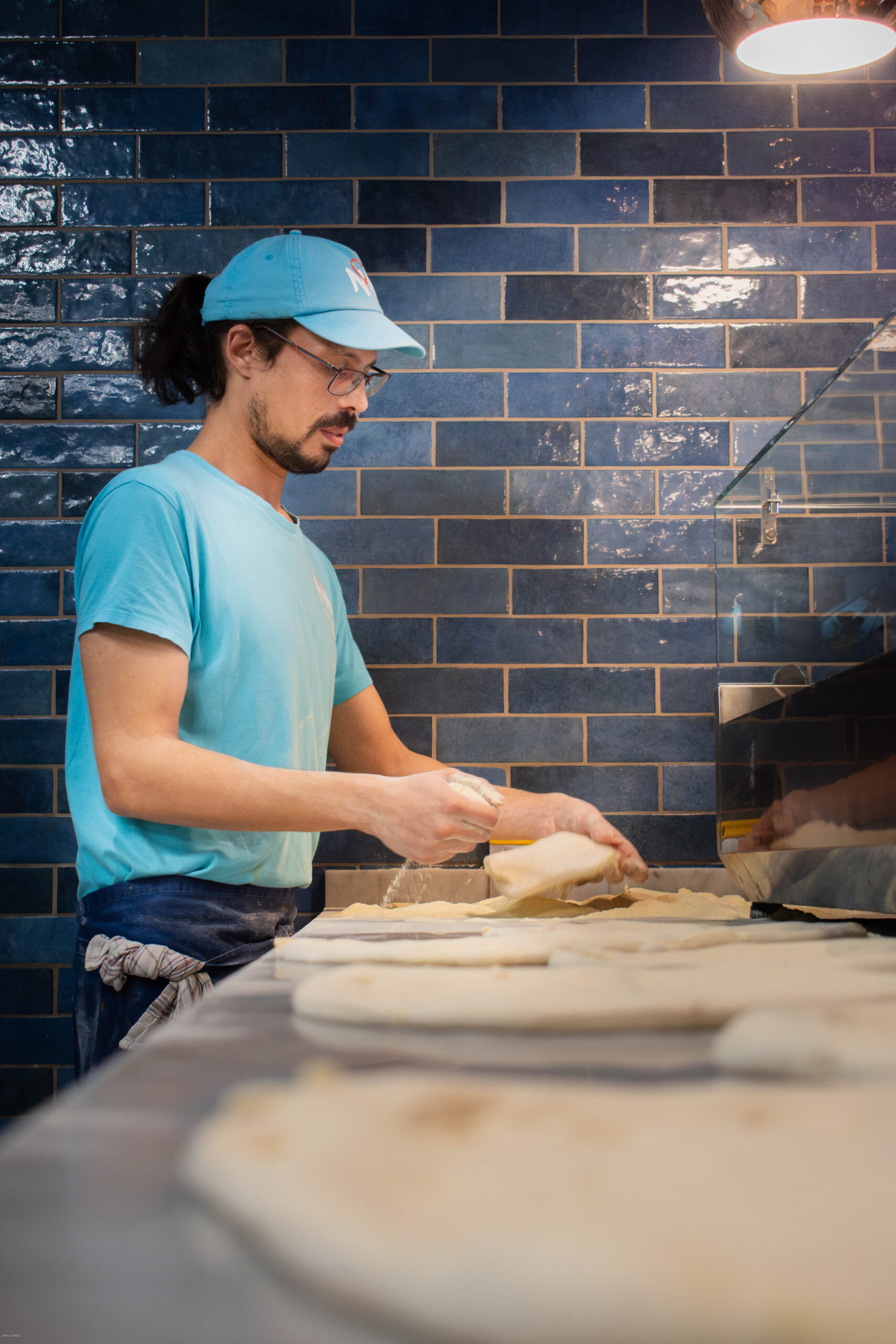 Salle chaleureuse de pizzeria avec four à bois allumé et pizzas partagées à table