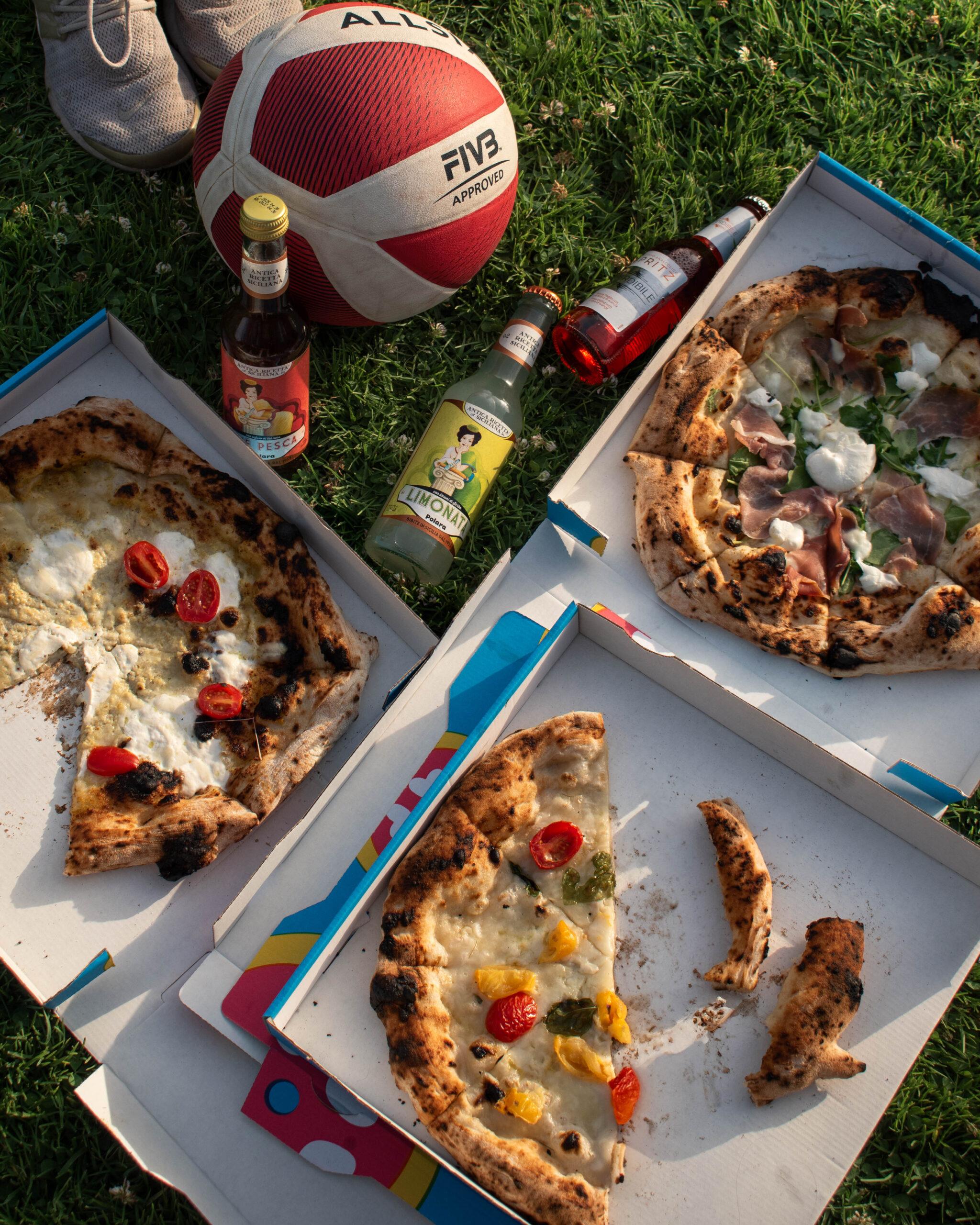 Pizzas variées sur table en bois, parts partagées et cartes du monde en arrière-plan