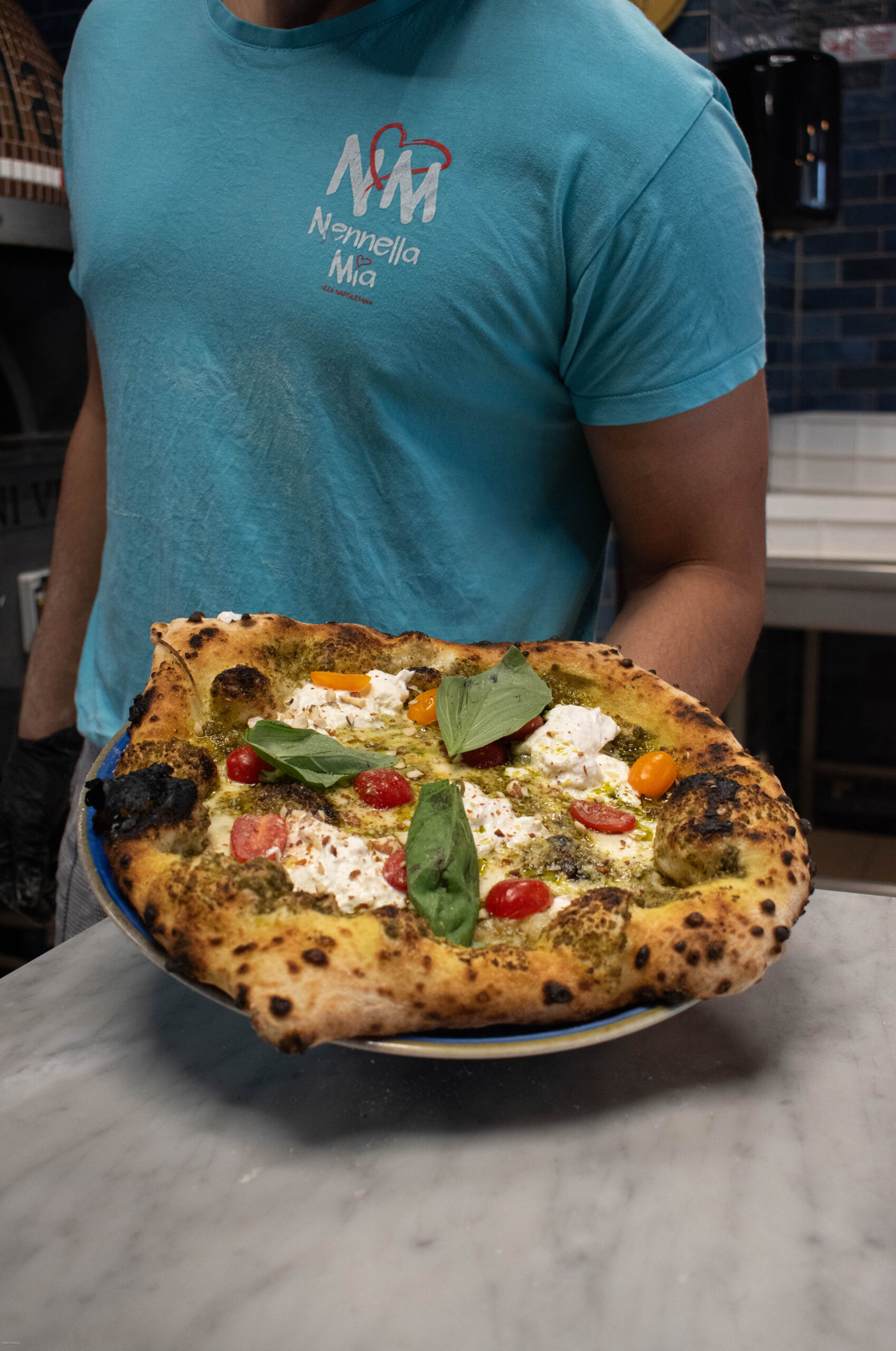 Salle de pizzeria au Bouscat, four à bois allumé et pizzaiolo au travail