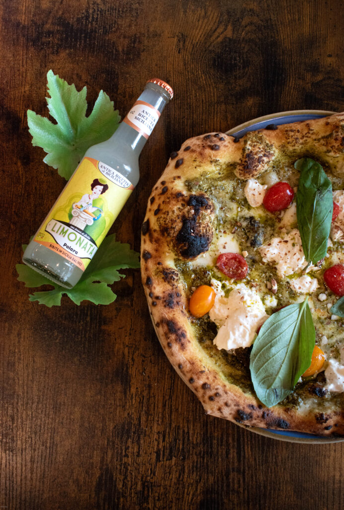 Pizza napolitaine sortant du four, cornicione gonflé, basilic et mozzarella fondue