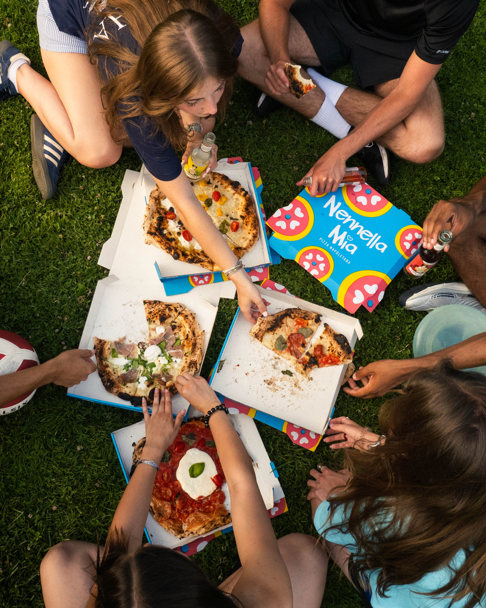 Salle chaleureuse de pizzeria, four à bois visible et clients dégustant sur place
