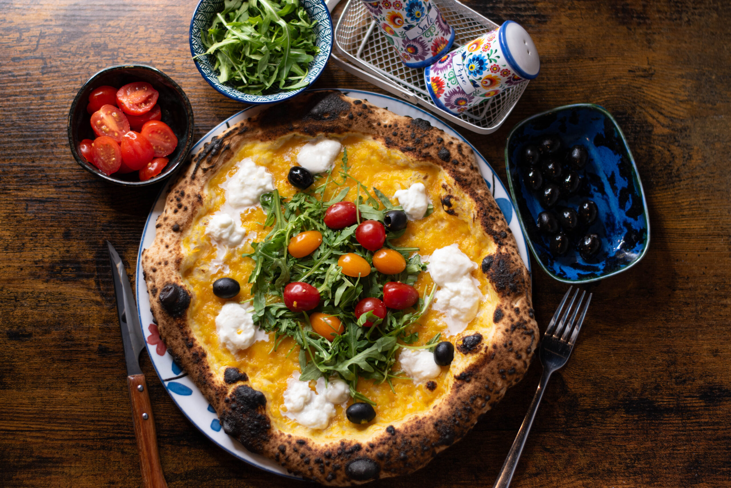 Pizza napolitaine en cuisson au four à bois, corniche gonflée et mozzarella fondante