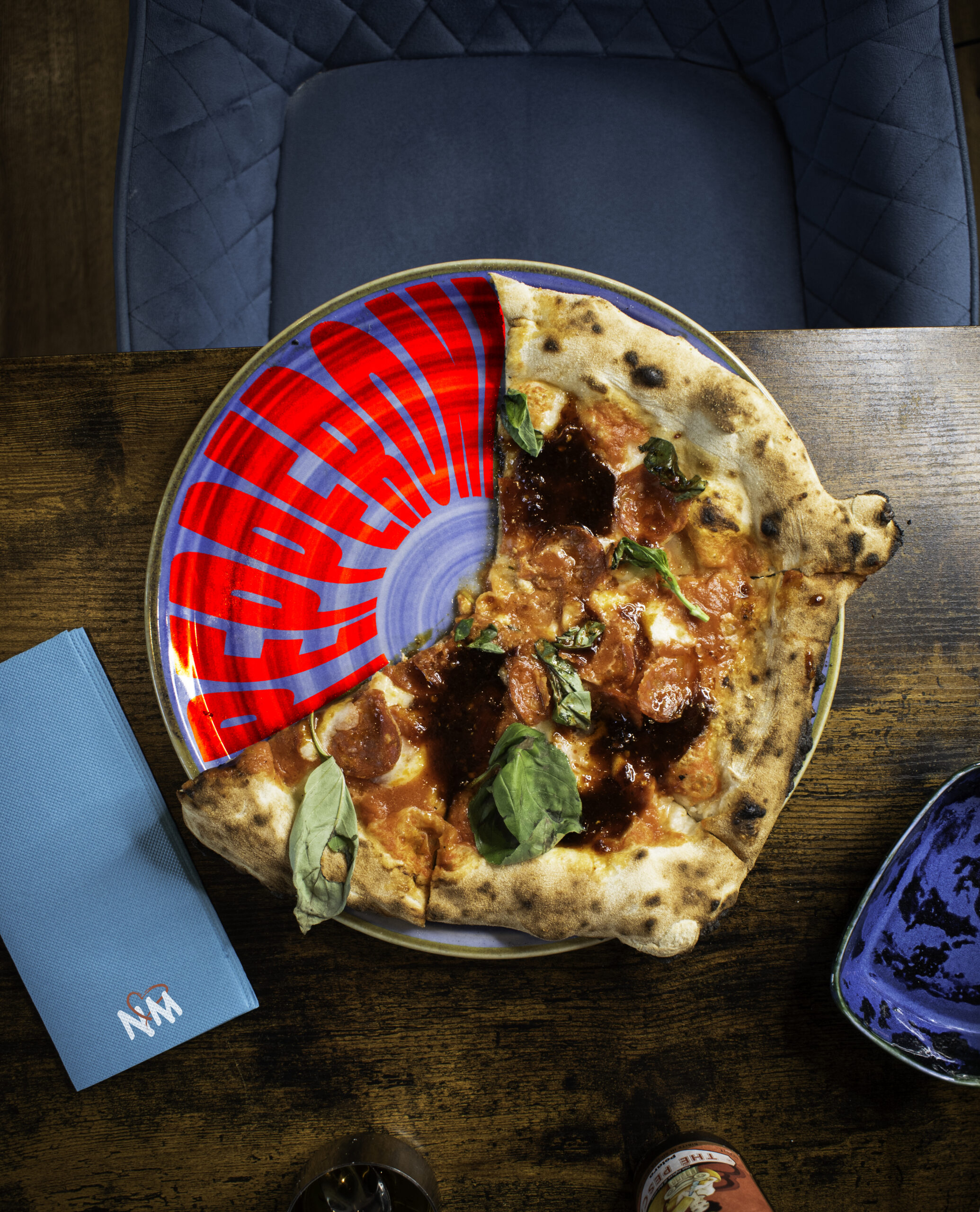 Pizzaiolo enfournant une pizza au four à 450°C, cornicione léopardé