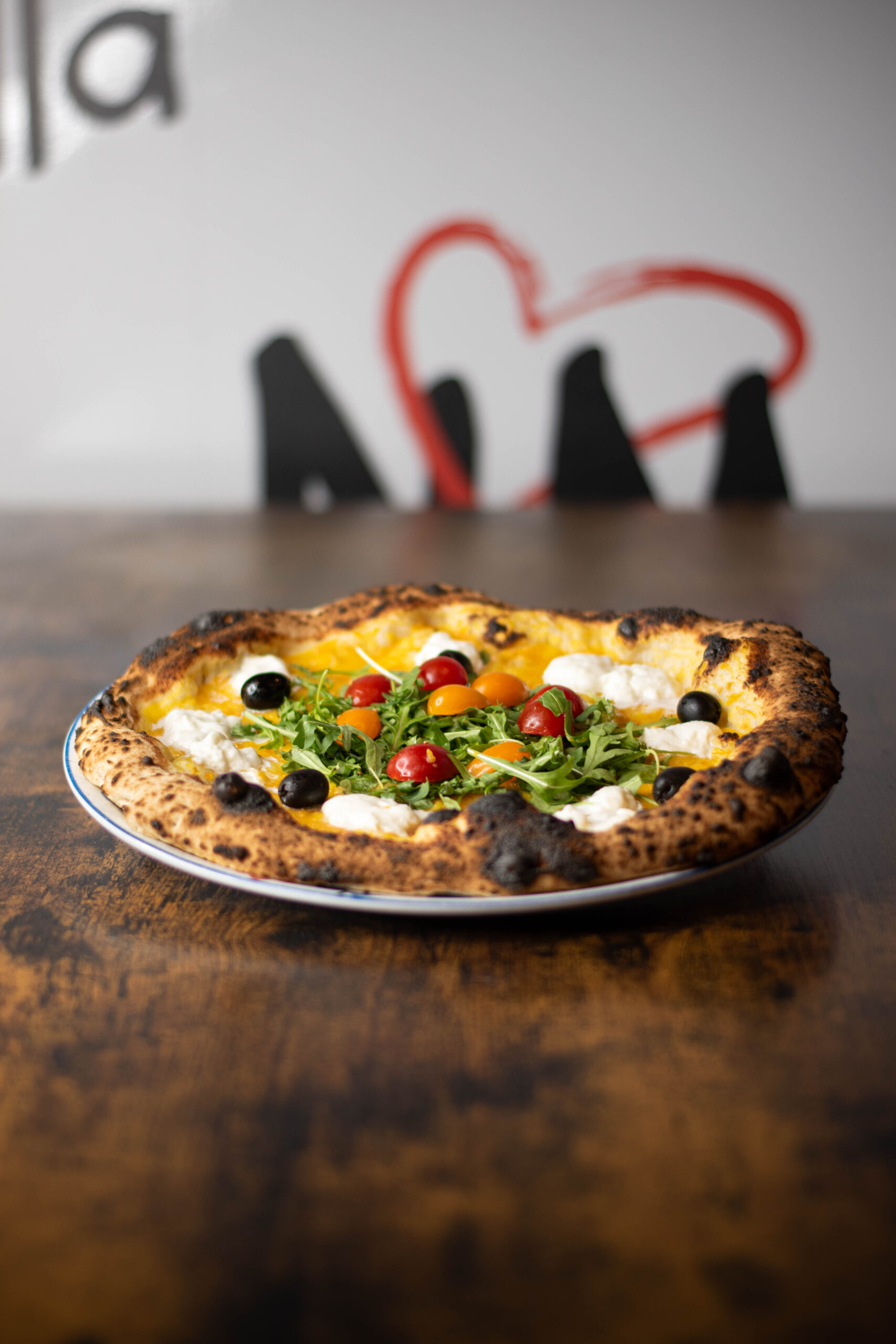 Intérieur de pizzeria napolitaine chaleureuse, tables dressées et four visible