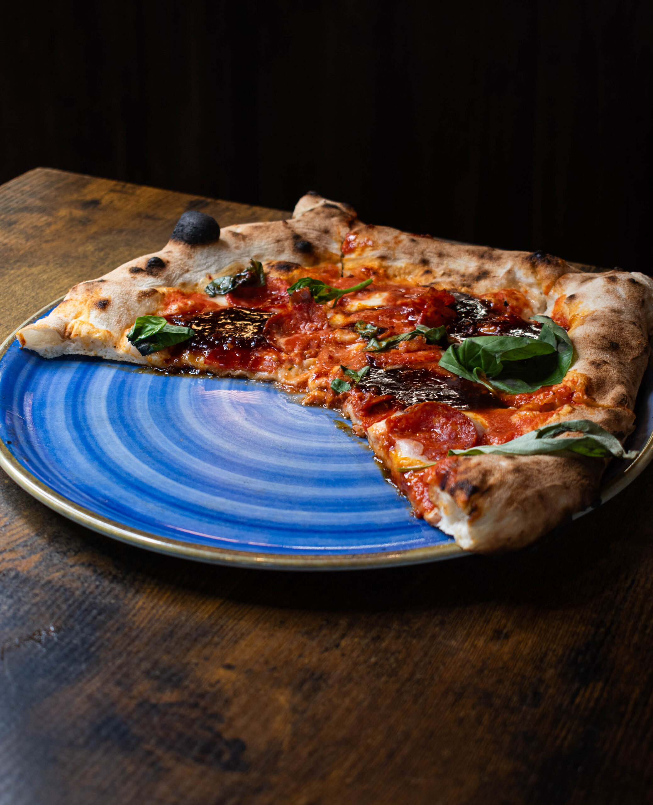 Salle de pizzeria au Bouscat, four à bois allumé et pizza à la truffe servie avec vin