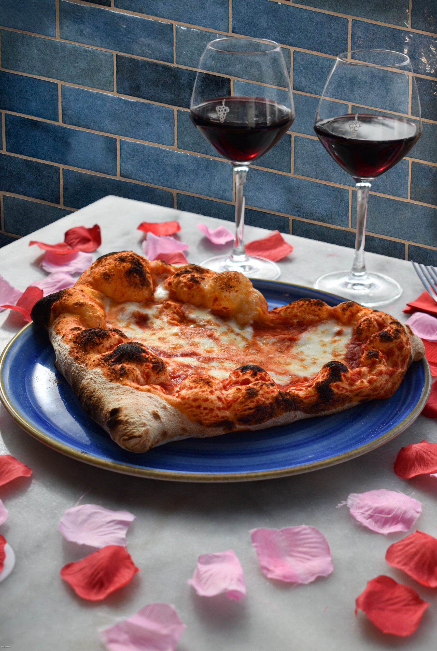 Salle tamisée avec bougies, table pour deux et pizzas servies chez Nennella Mia au Bouscat
