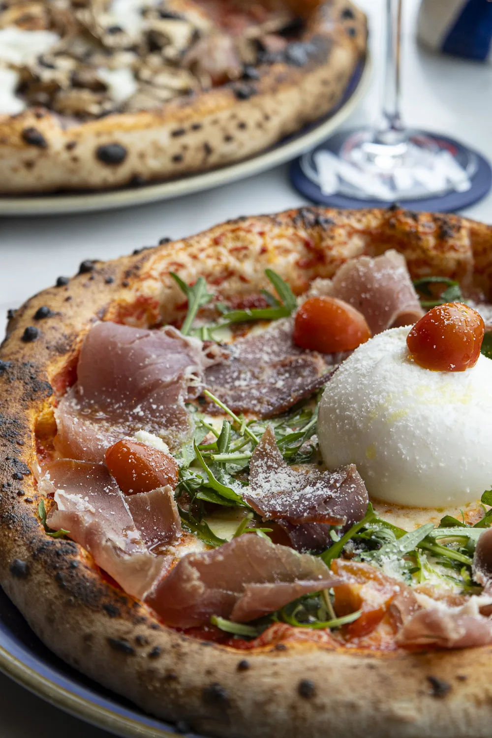 Deux pizzas napolitaines sur table: Margherita basilic et Marinara à l’ail