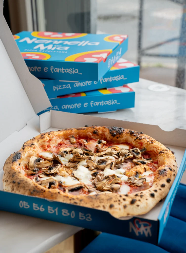 Boîte ouverte avec deux pizzas côte à côte, clin d’œil au slogan « Pizza! Pizza! »