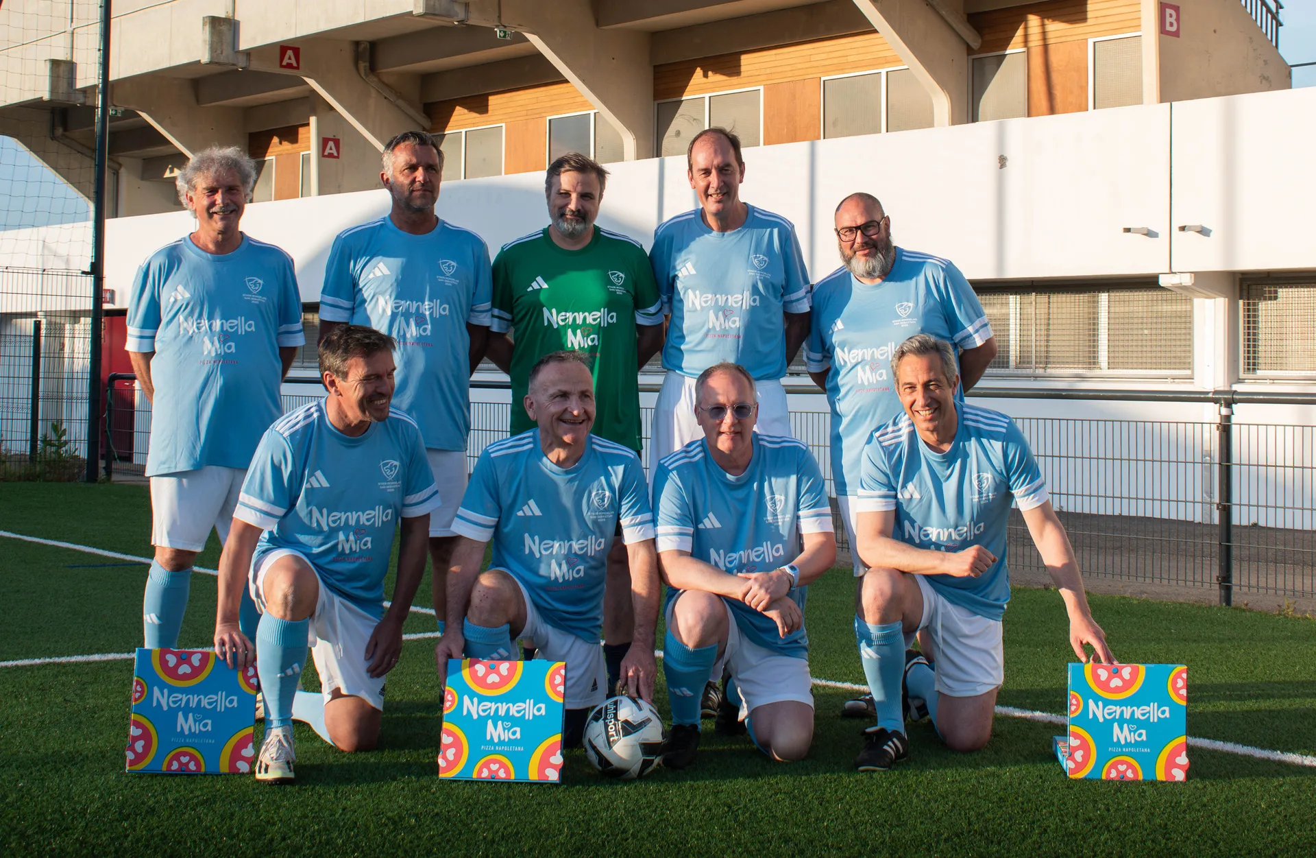 Pizza napolitaine partagée sur table festive, drapeau italien en arrière-plan