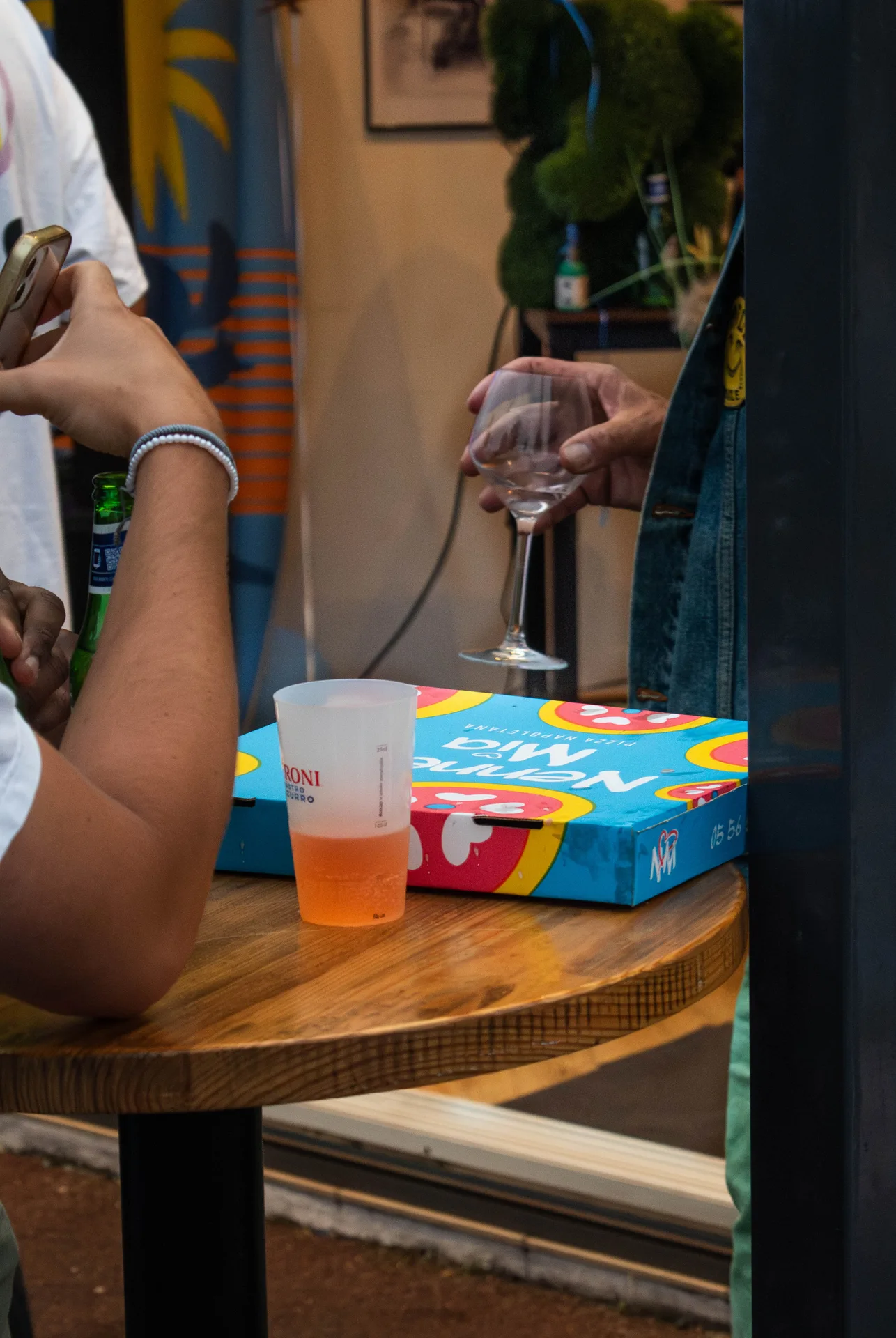 Salle de trattoria animée au Bouscat, pizzas servies et verres qui trinquent