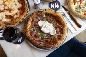 Pâte à pizza qui lève près d’un four, farine sur le plan de travail