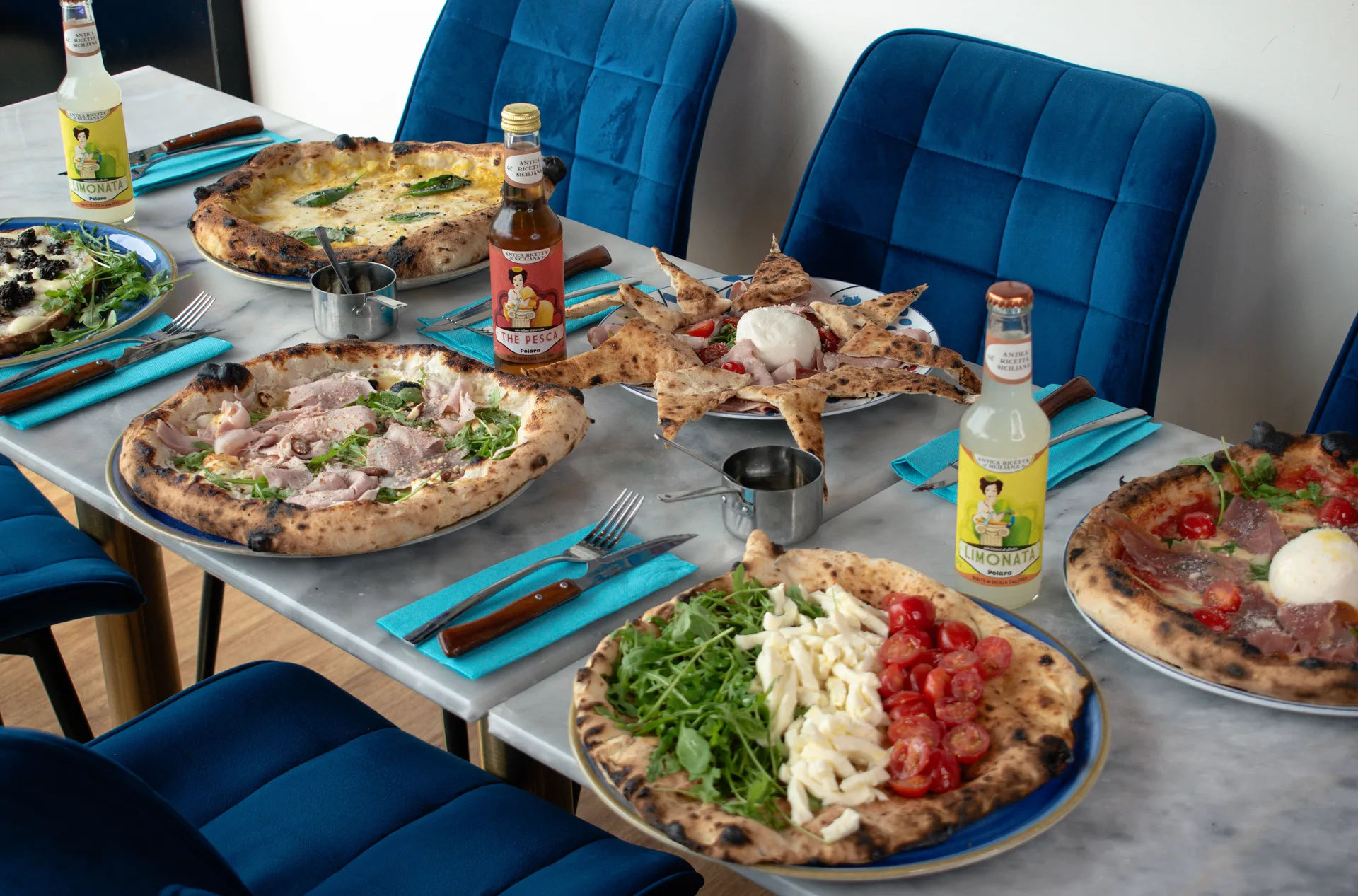 Pizza Margherita en parts sur table, croûte dorée et fromage filant