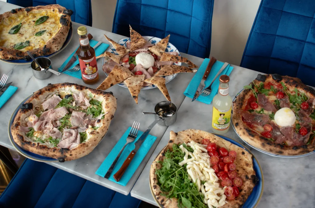 Pizza napolitaine fumante, croûte dorée, basilic frais sur table conviviale