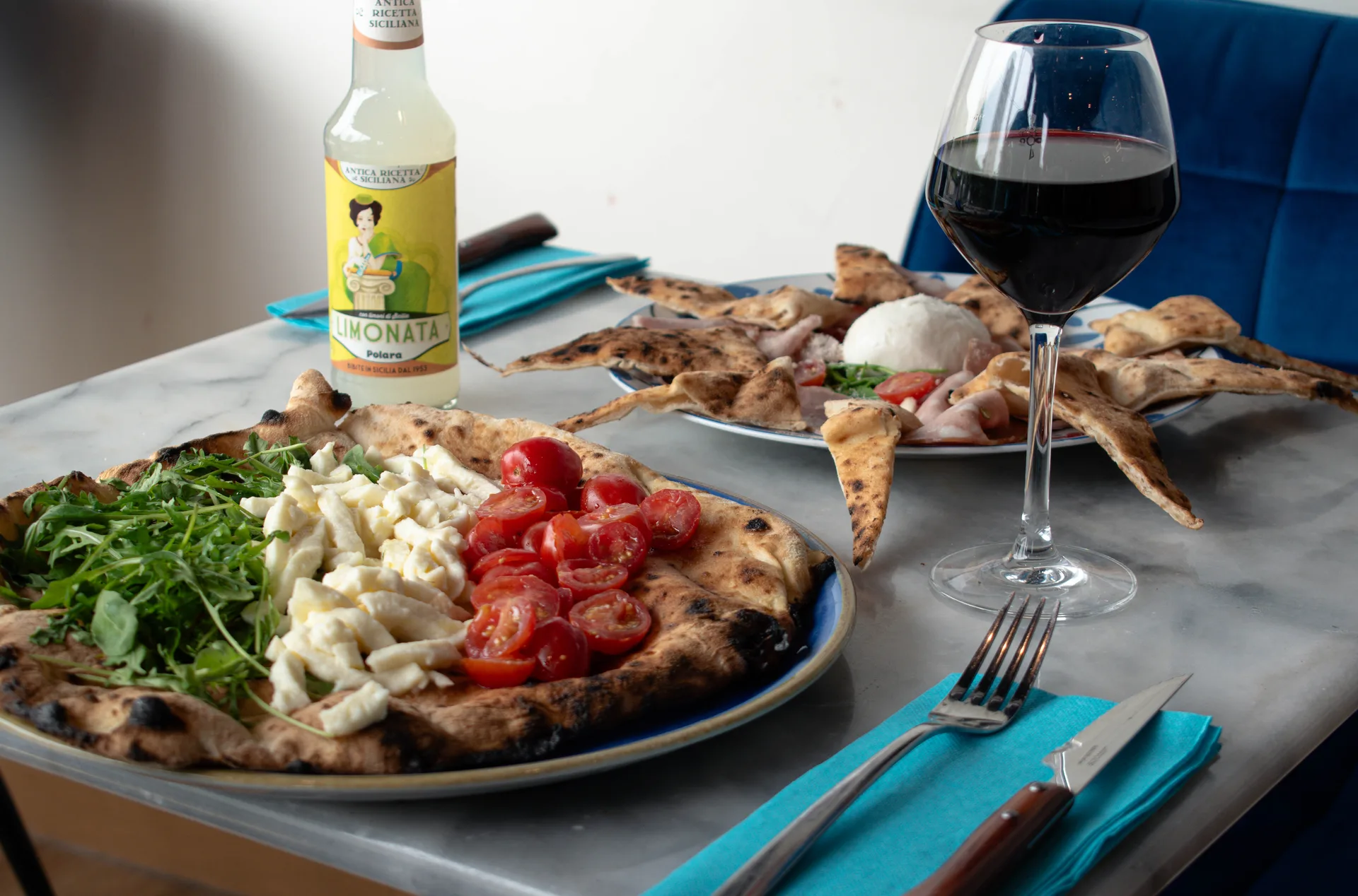 Salle de trattoria chaleureuse au Bouscat, tables animées et four à pizza au fond