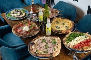 Pizza napolitaine croute alvéolée, basilic frais et tomates, sur table de midi