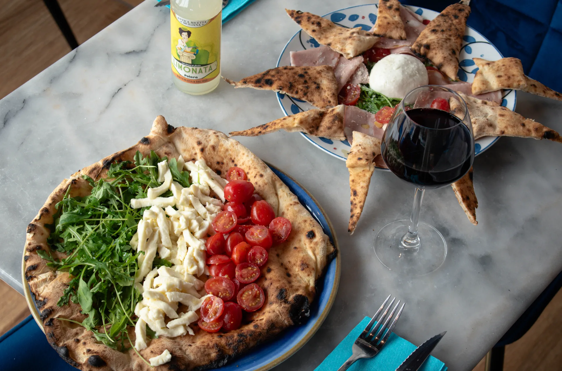 Pizzaiolo sort une pizza du four à bois, salle conviviale pour déjeuner à emporter