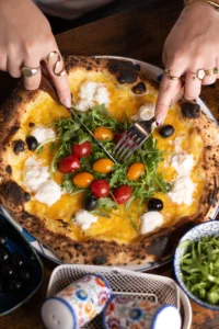Famille attablée au Bouscat, pizzas napolitaines au centre, ambiance de Pâques