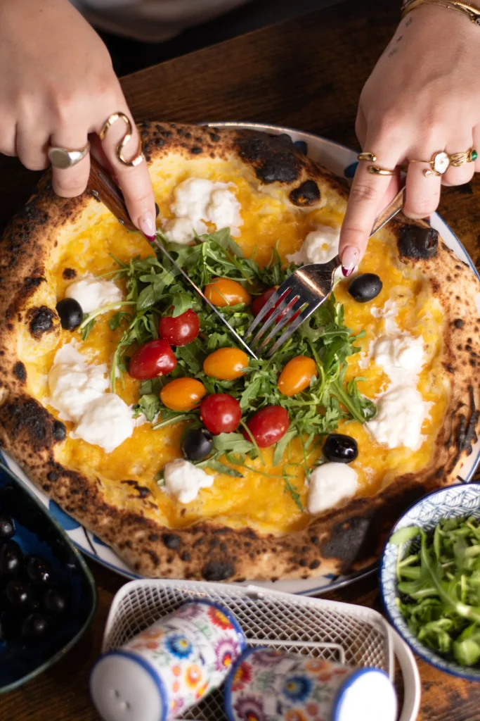 Famille attablée au Bouscat, pizzas napolitaines au centre, ambiance de Pâques