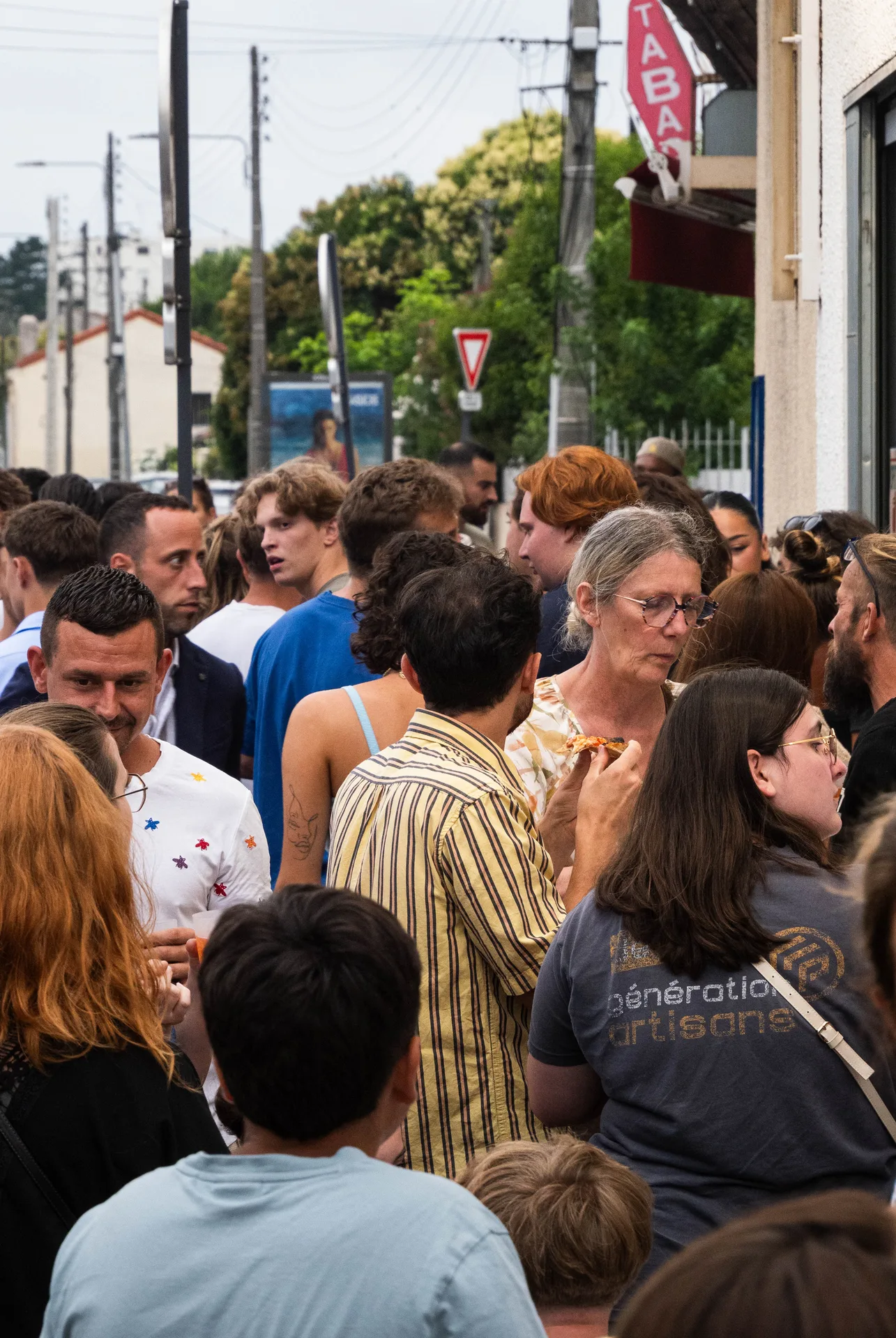 Salle chaleureuse de pizzeria à Bordeaux, clients attablés près du four allumé