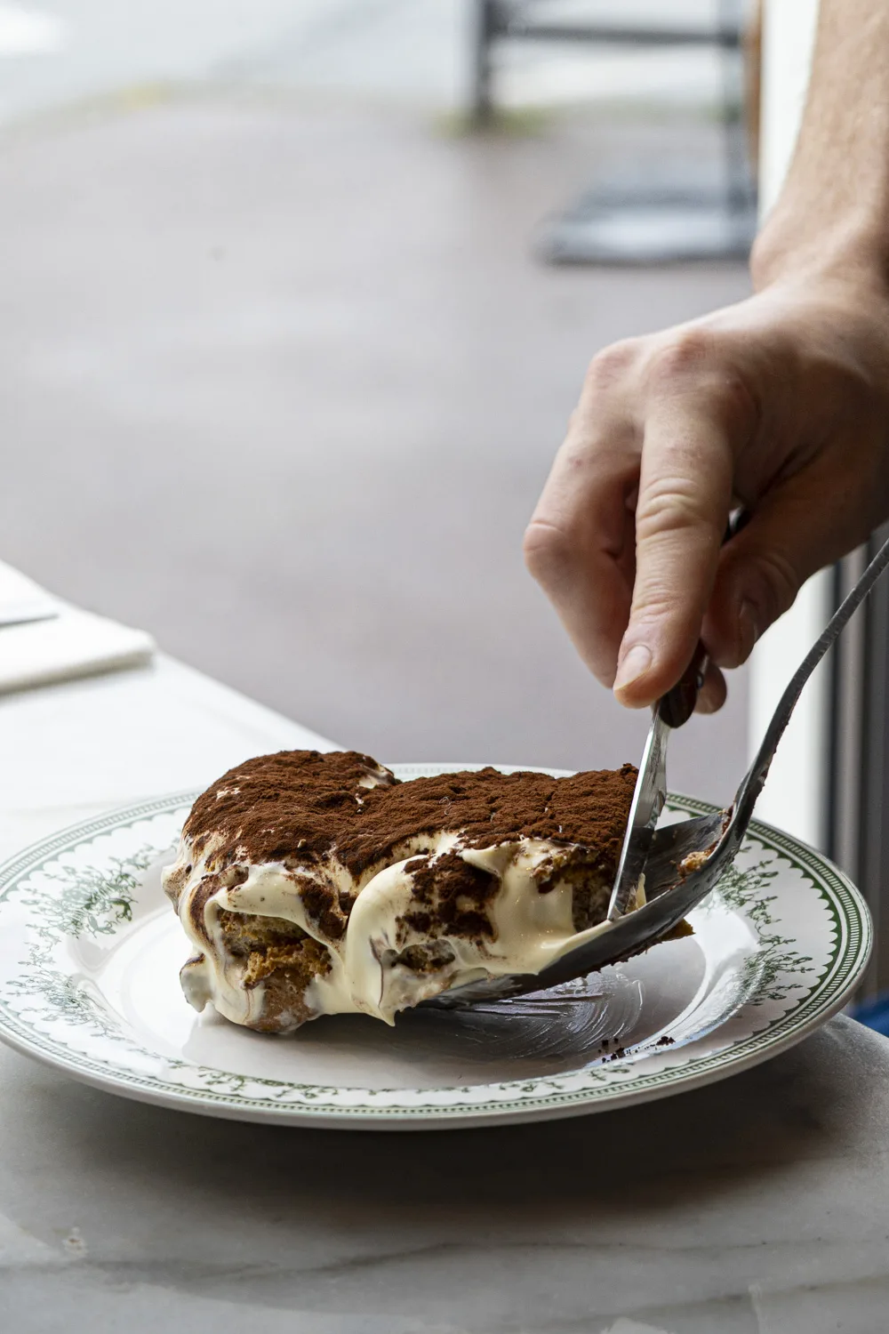 Salle de pizzeria animée à Bordeaux, serveur souriant et four à bois en arrière-plan