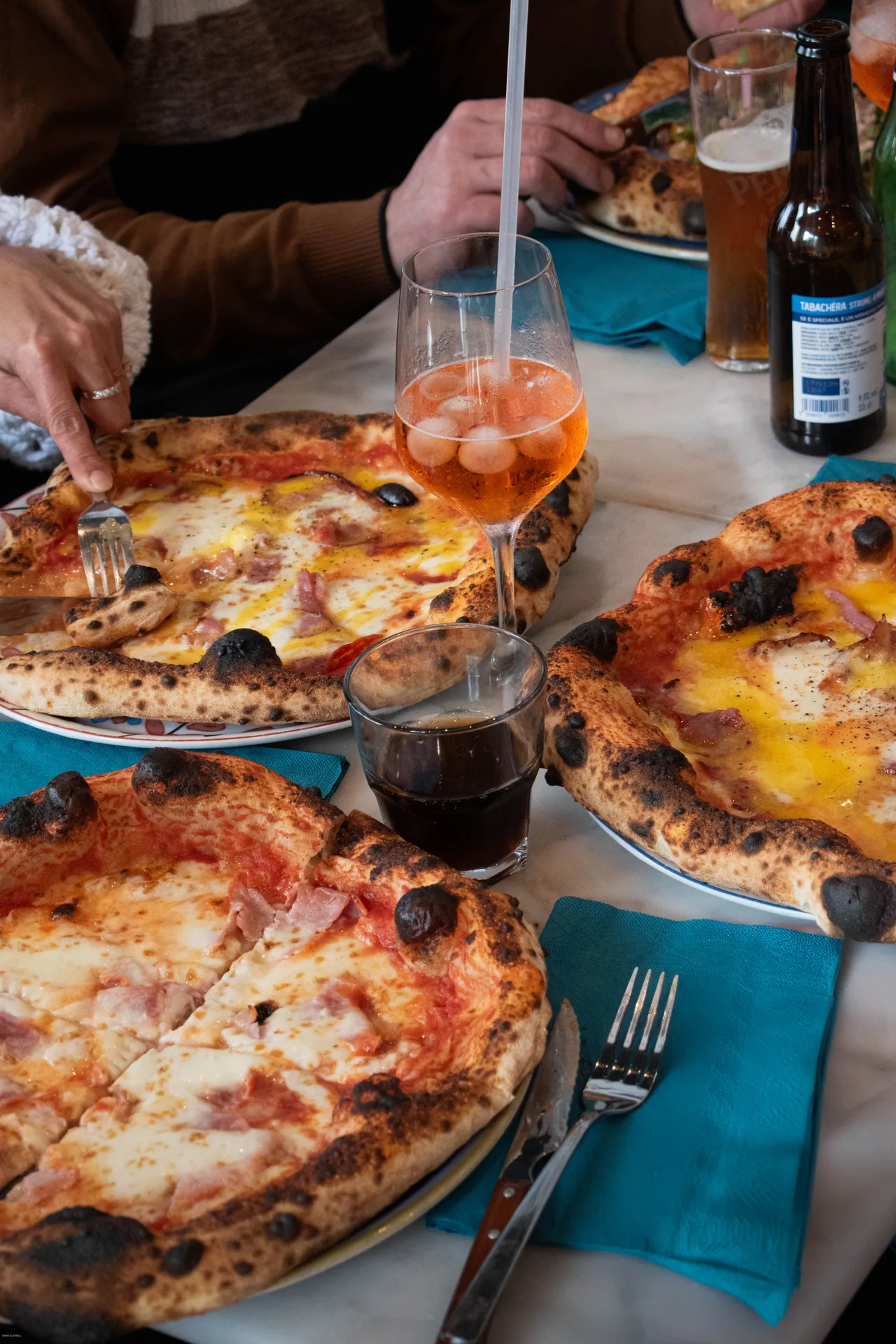 Mains étalant une pâte à pizza, bords gonflés et centre fin sans rouleau