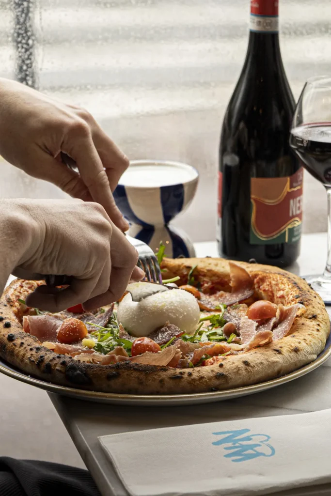 Pizza napolitaine pliée avec cornicione gonflé, sortie d’un four à bois