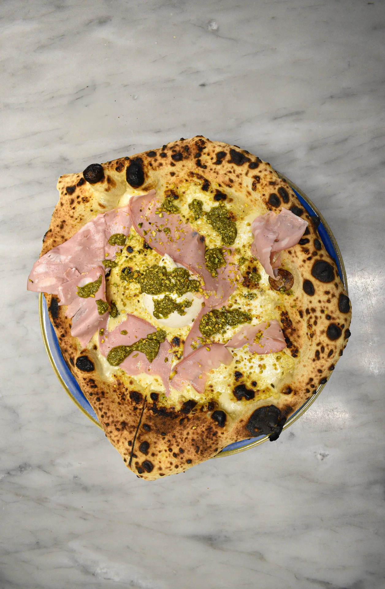 Pizzaiolo devant four à bois à Naples, étalant pâte avec tomates et mozzarella