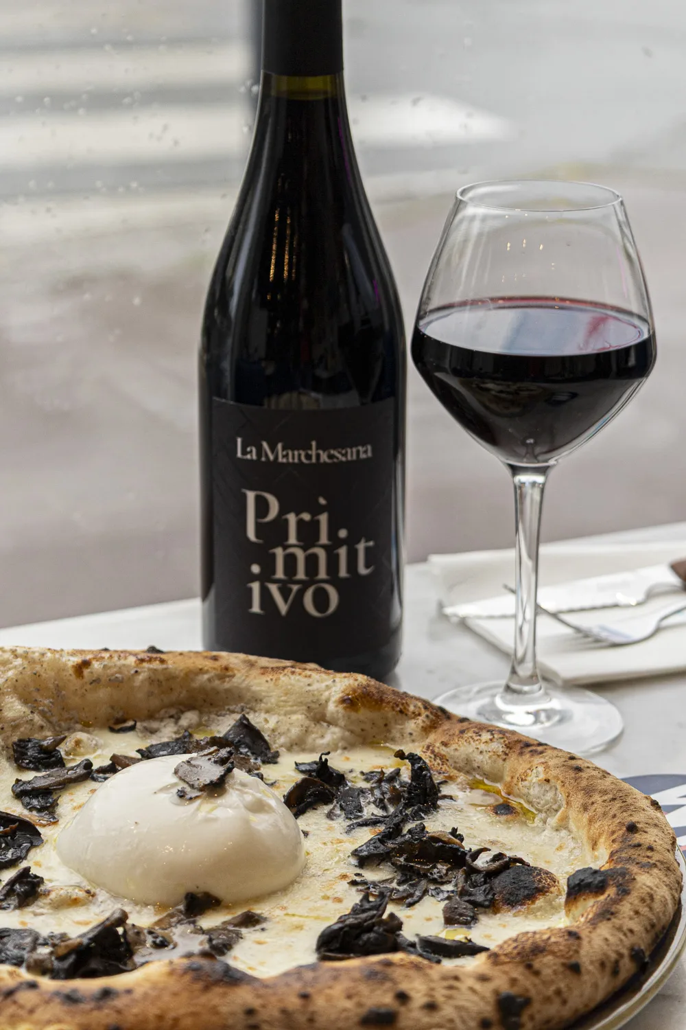 Salle de pizzeria animée au Bouscat, clients autour du four à bois et serveurs souriants