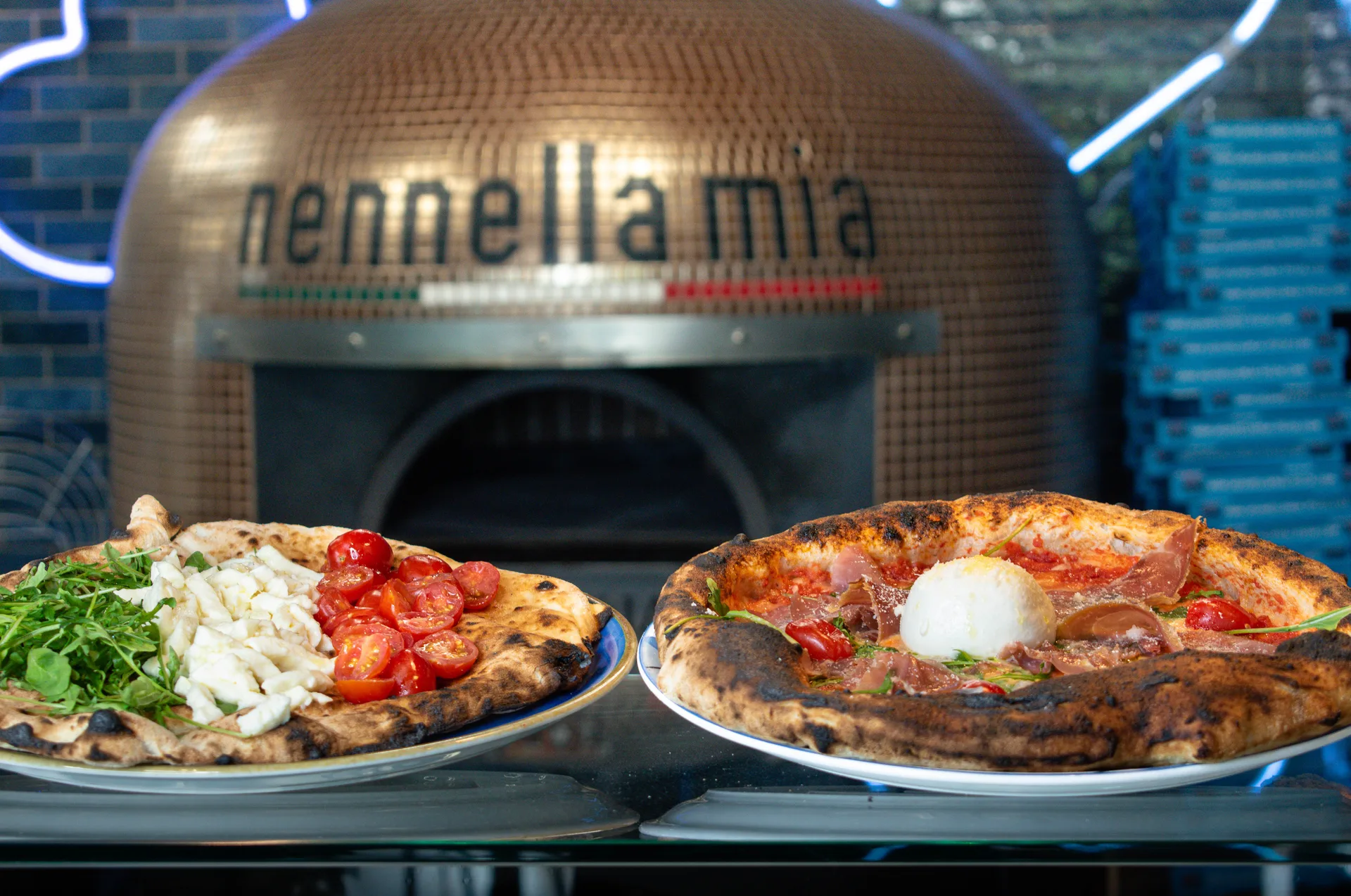 Salle chaleureuse de pizzeria napolitaine au Bouscat, four à bois en arrière-plan