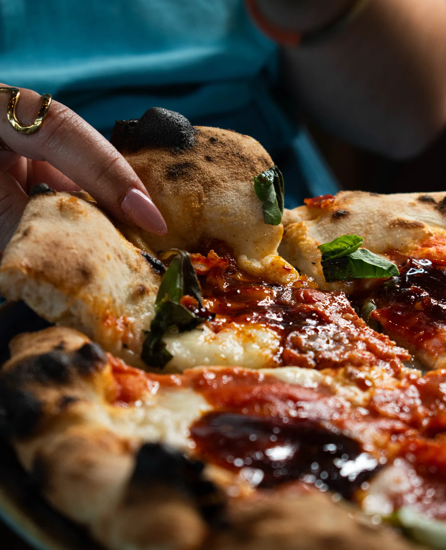 Pizza napolitaine pepperoni au four à bois, corniche alvéolée, basilic et filet d'huile