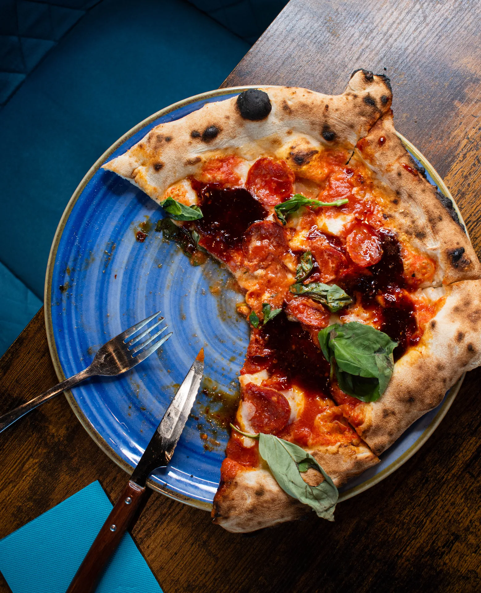 Salle chaleureuse de pizzeria napolitaine au Bouscat, tables en bois et four visible