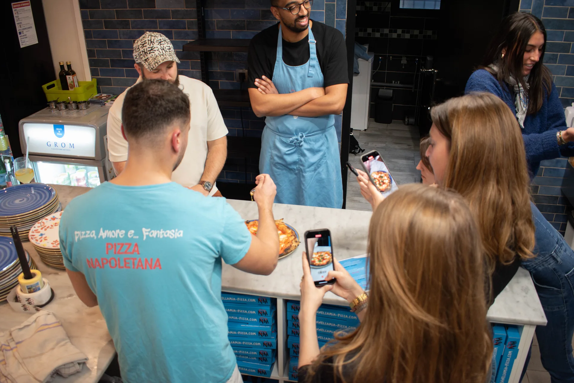 Salle de trattoria au Bouscat, grandes tables et four à bois en arrière-plan
