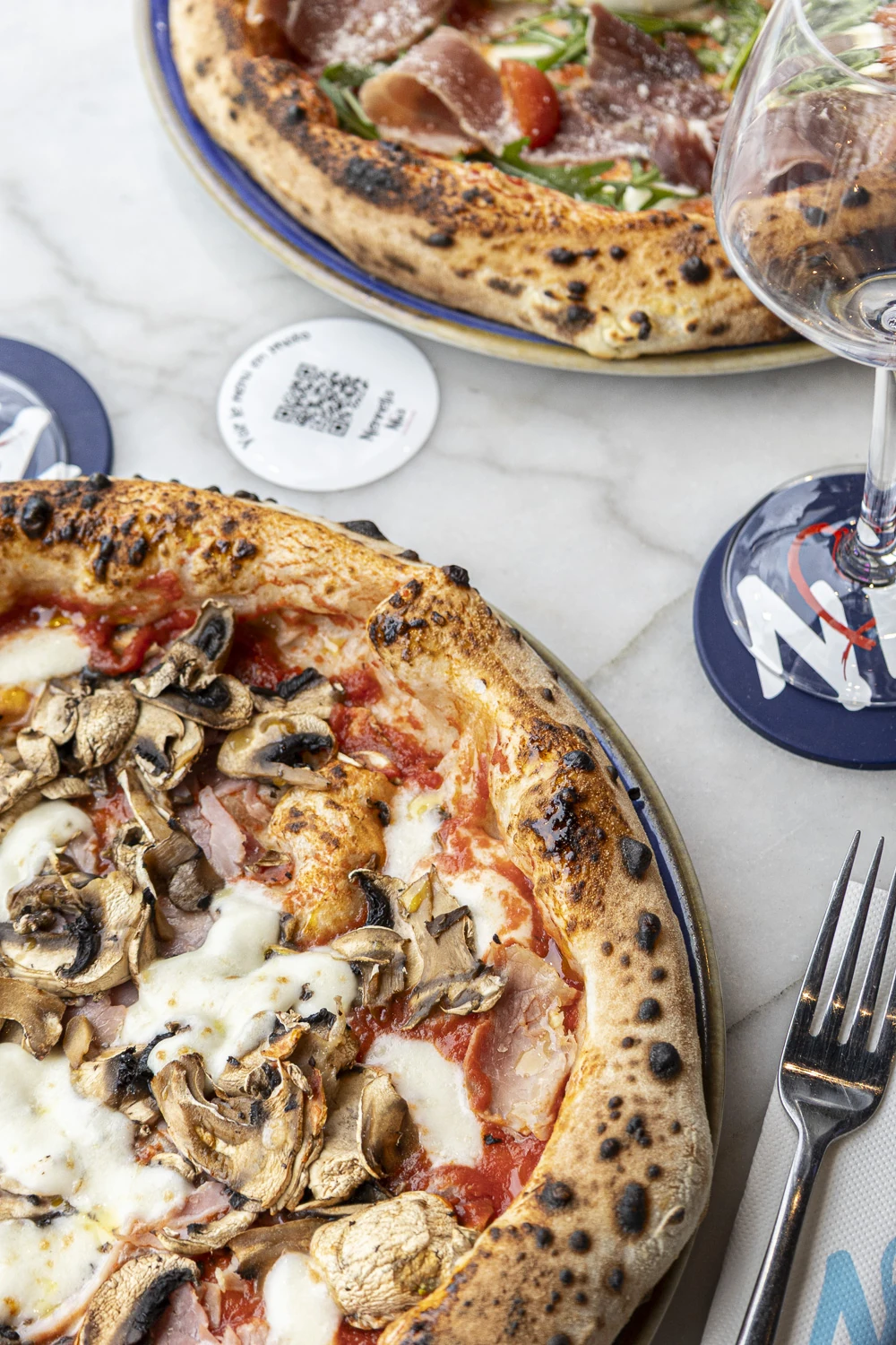 Salle de pizzeria au Bouscat, clients regardant un match, pizzas à partager sur tables