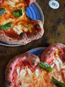 Pizza napolitaine coupée, centre très fin et bord gonflé, cuisson léopardée