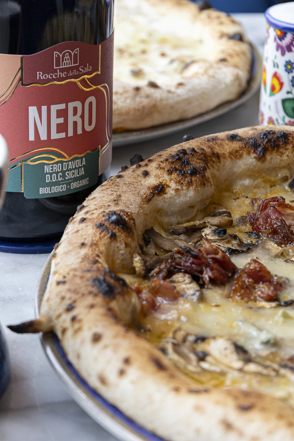 Pizzas Reine, 4 fromages et Margherita alignées près d’un four napolitain