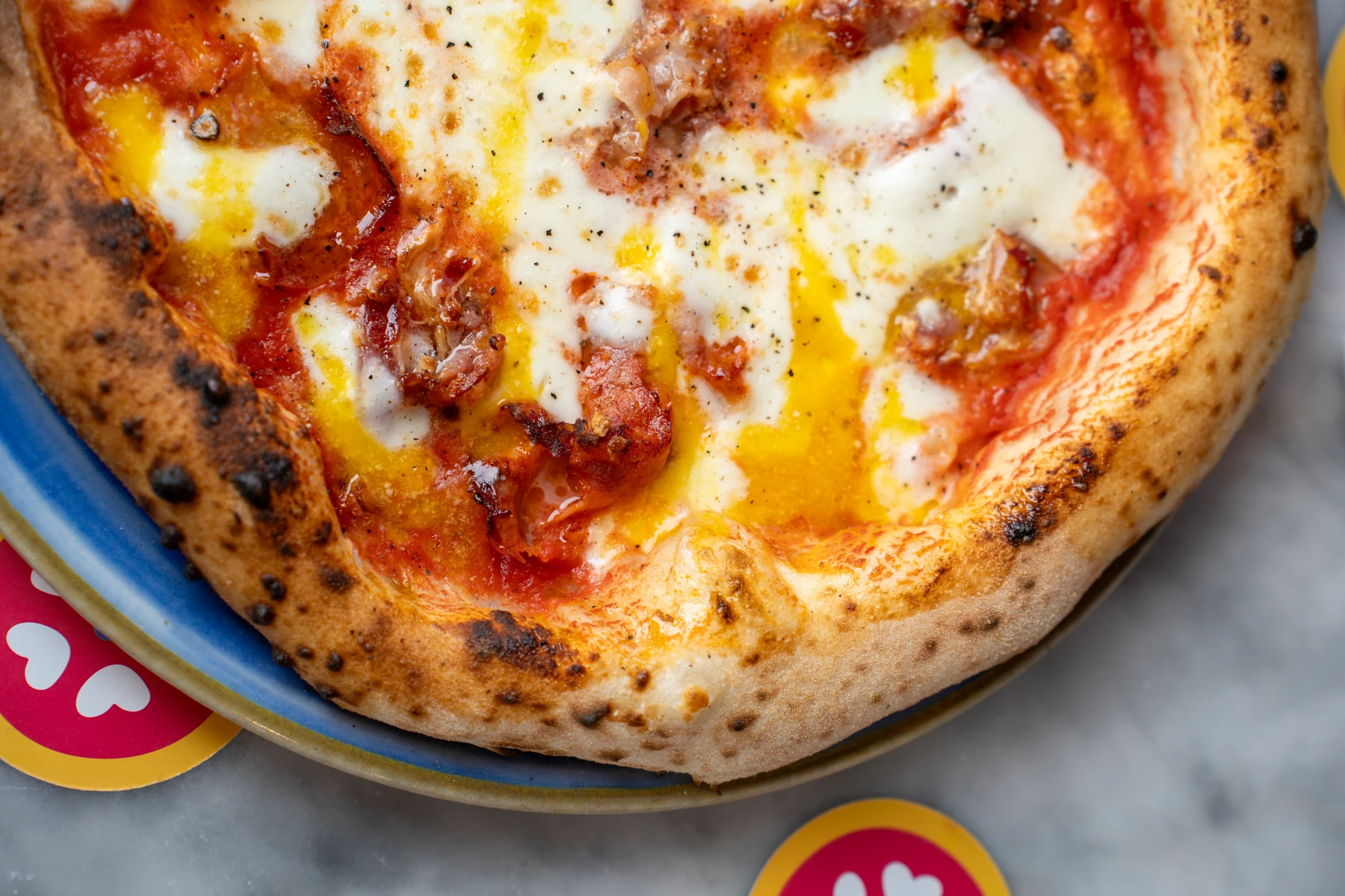Salle chaleureuse de pizzeria au Bouscat, pizzas à emporter et verres de vin