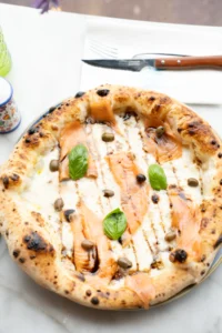 Pizza bianca sans sauce tomate, huile d’olive et herbes sur pâte dorée