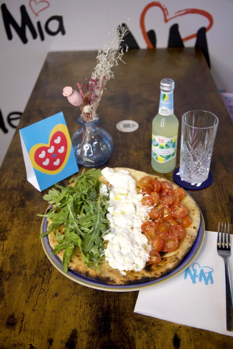 Focaccia Italiana en bandes de roquette, fior di latte et tomates cerises, sur une table en bois de Nennella Mia
