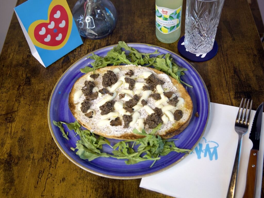 Bruschetta Truffe de Nennella Mia : ricotta à la truffe, fior di latte et copeaux de truffe sur une assiette bleue