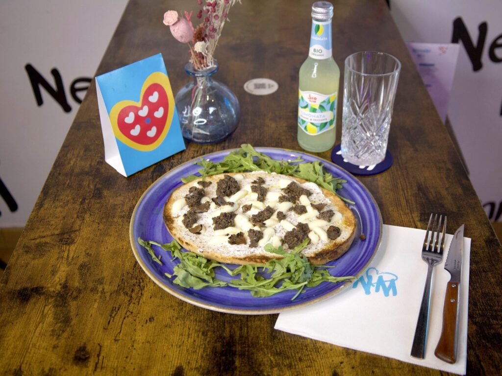 Bruschetta Truffe servie sur une table en bois de Nennella Mia, avec une limonade bio