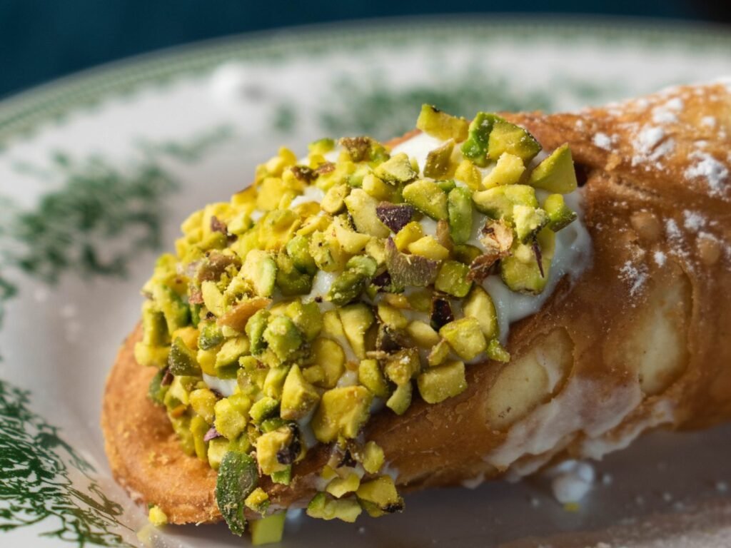 Gros plan sur le cannolo de Nennella Mia : crème de ricotta et pistache concassée