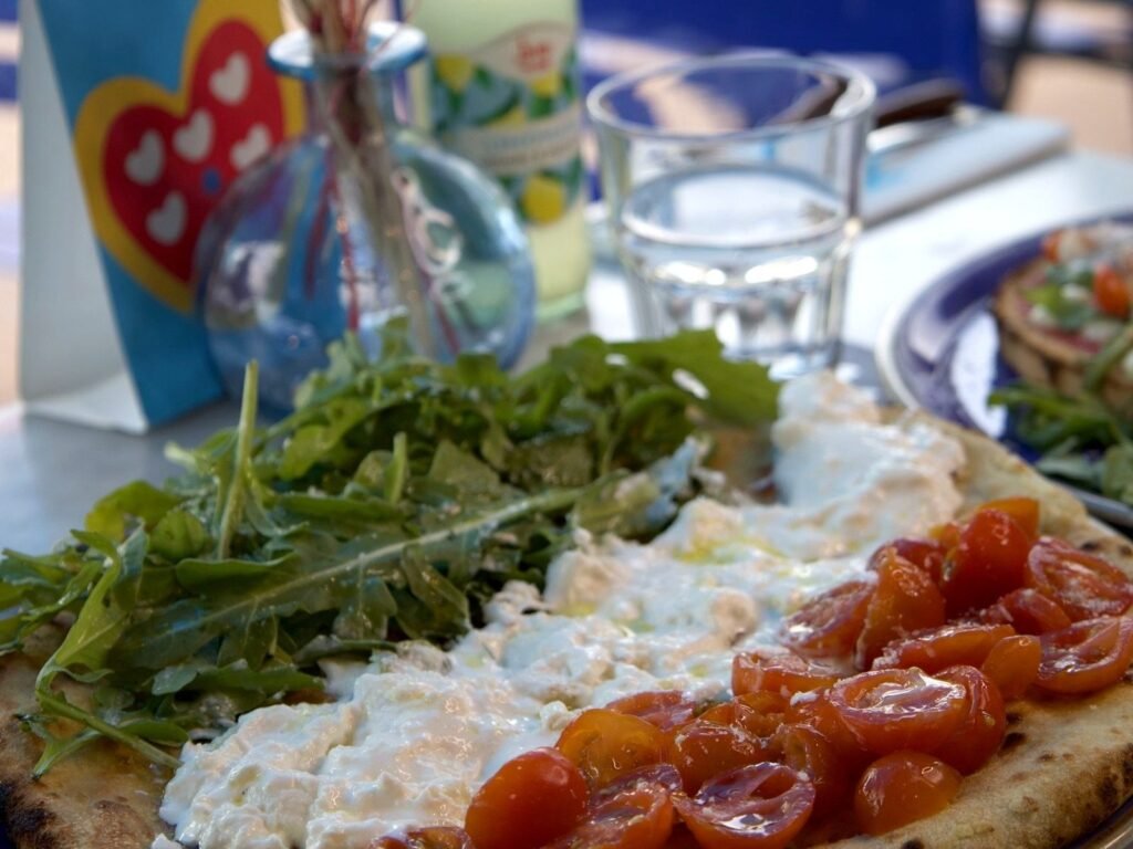 Gros plan sur la Focaccia Italiana : roquette, fior di latte crémeuse et tomates cerises marinées