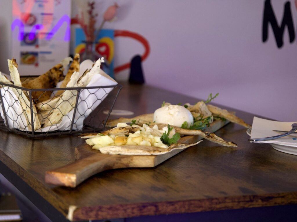 Planche Solo formaggi et sa corbeille de pain sur une table de la salle de Nennella Mia