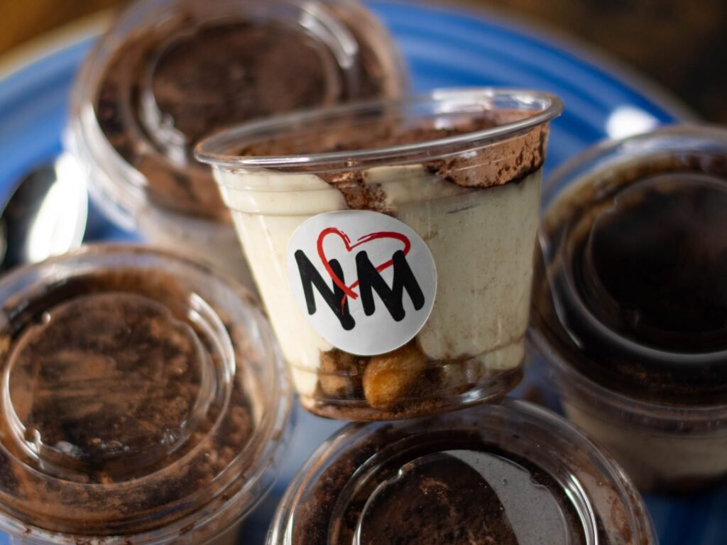 Plusieurs pots de tiramisù Nennella Mia réunis sur une assiette bleue