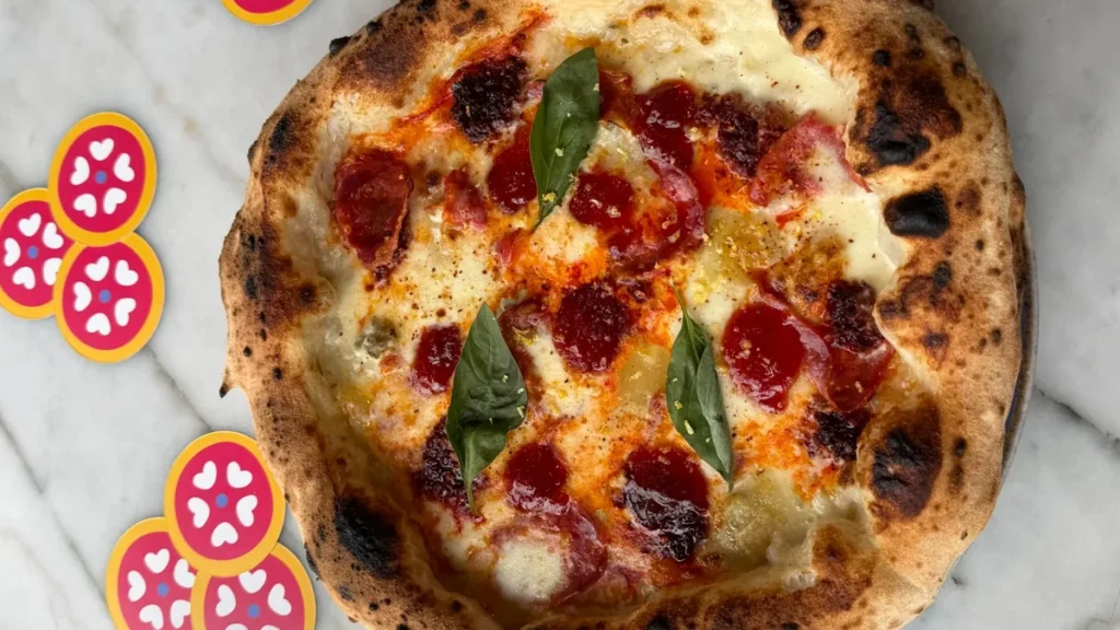 Pizza Demogorgon : spianata, nduja de Calabre, confiture de tomate, basilic et zeste de citron sur crème de parmesan, mozzarella et gorgonzola